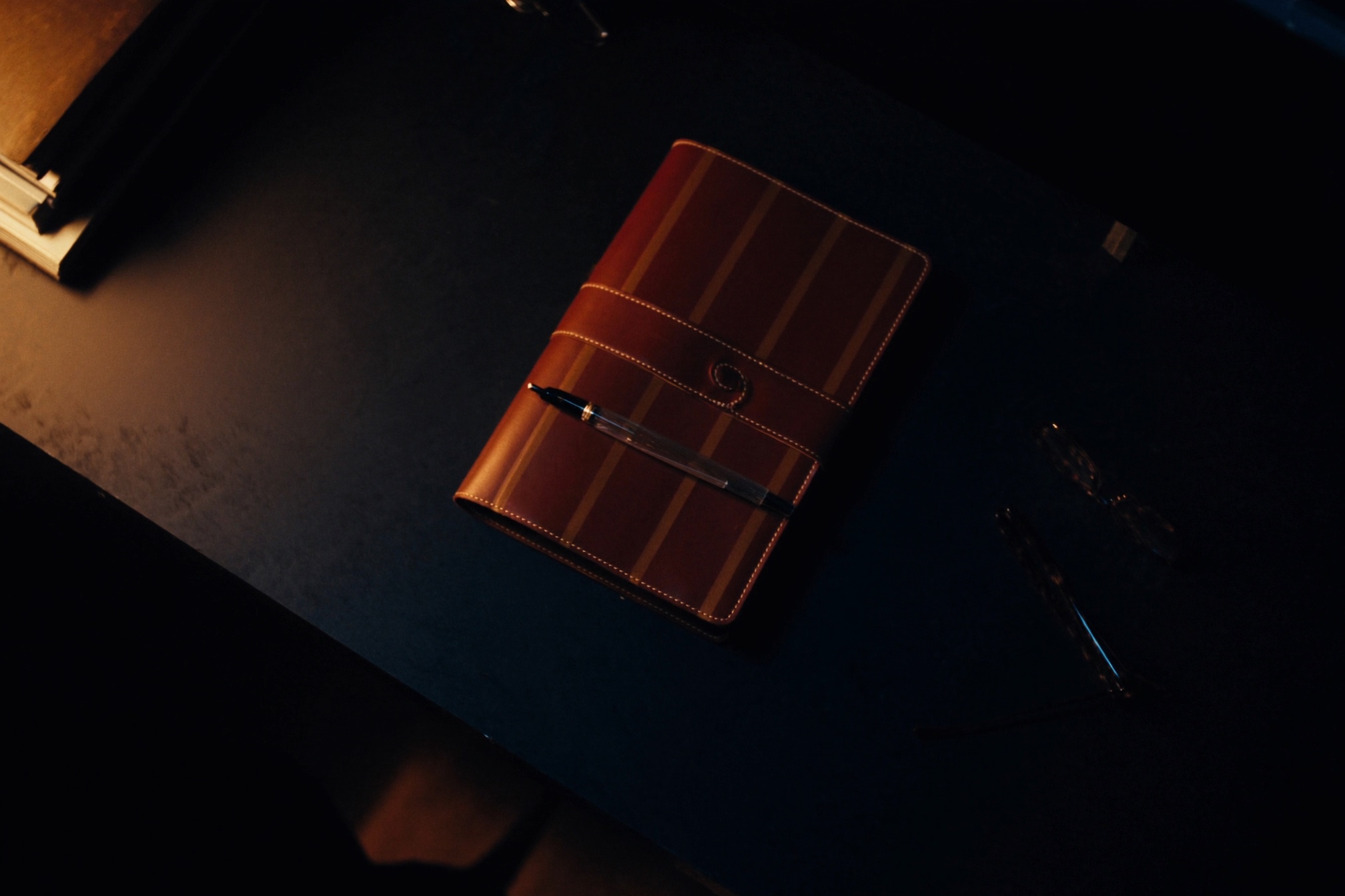 A leather portfolio and fountain pen on a desk